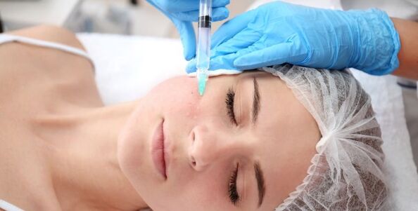 Kosmetologė atlieka veido odos atjauninimo procedūrą su plazma